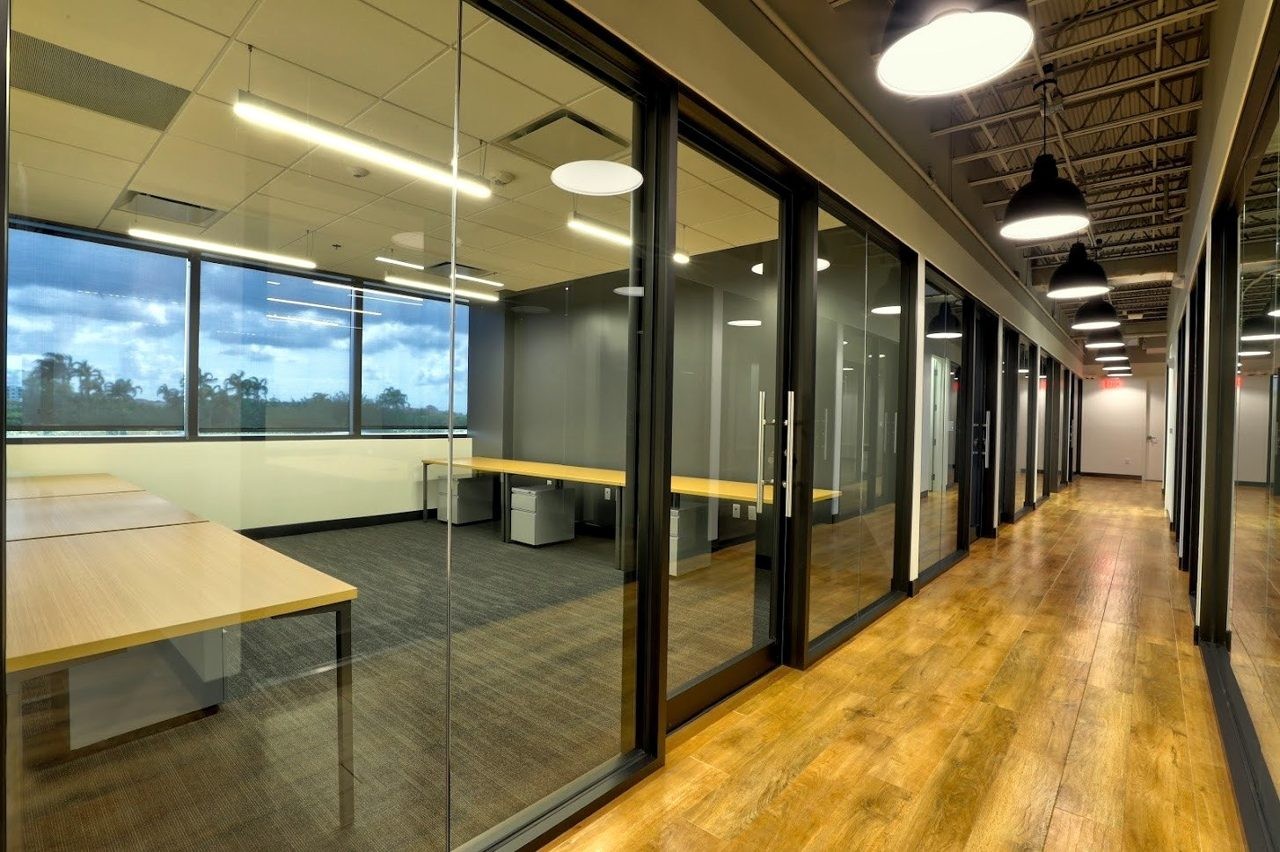 Frameless and framed interior glass walls lining an office corridor